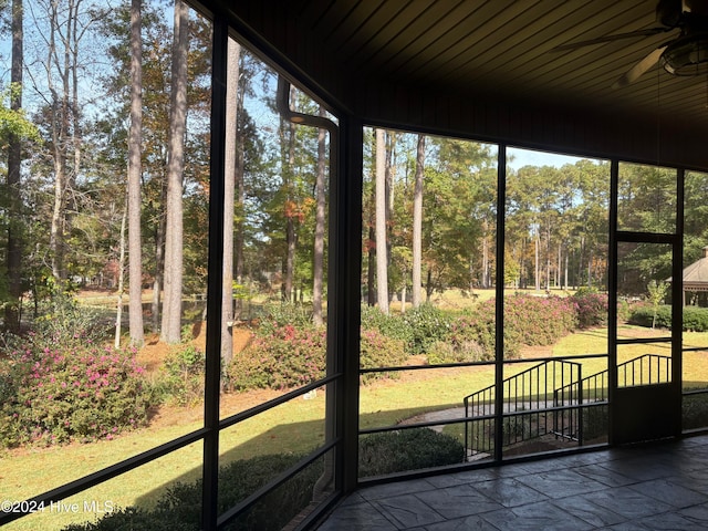 unfurnished sunroom featuring ceiling fan