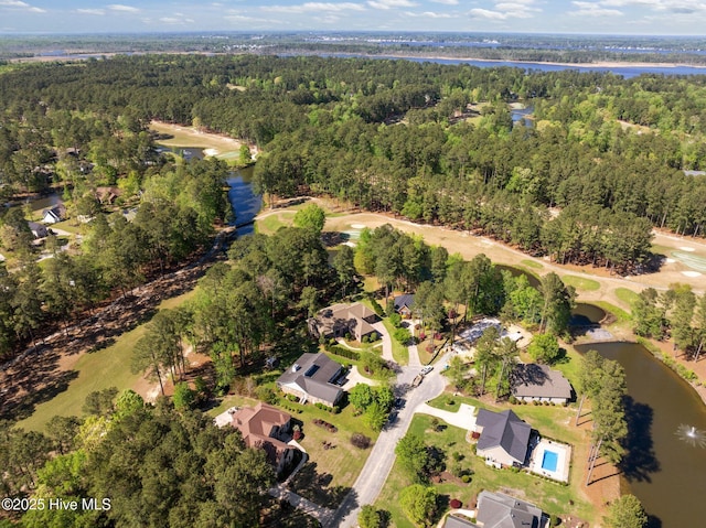 bird's eye view featuring golf course view, a view of trees, a residential view, and a water view