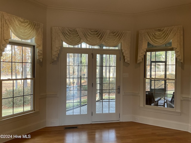 doorway to outside featuring crown molding and hardwood / wood-style floors