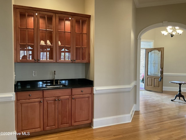 bar with sink and light hardwood / wood-style flooring