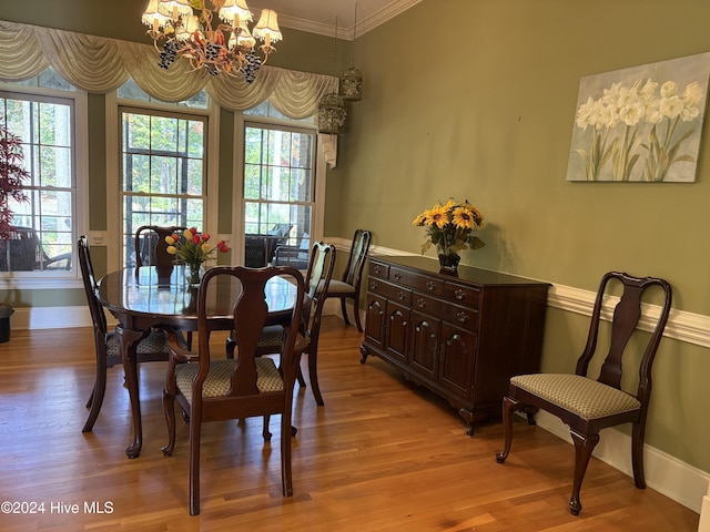 dining room with crown molding, a healthy amount of sunlight, a chandelier, and light wood-type flooring