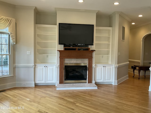 unfurnished living room with ornamental molding and light hardwood / wood-style floors