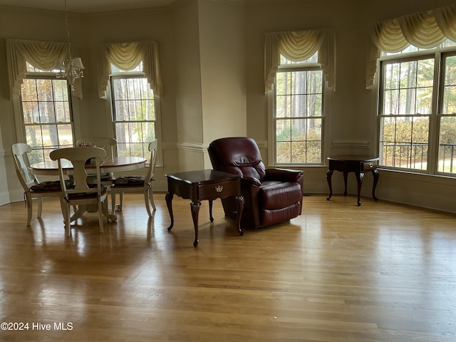 living area with plenty of natural light, a chandelier, and hardwood / wood-style floors