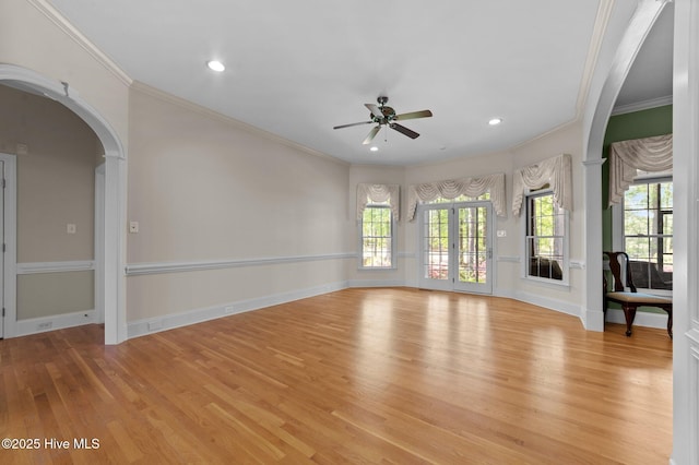 unfurnished room with light wood-style flooring, a ceiling fan, and crown molding