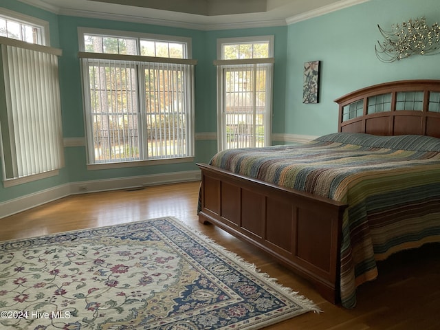 bedroom featuring wood-type flooring and crown molding