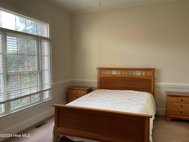 carpeted bedroom with ornamental molding and multiple windows