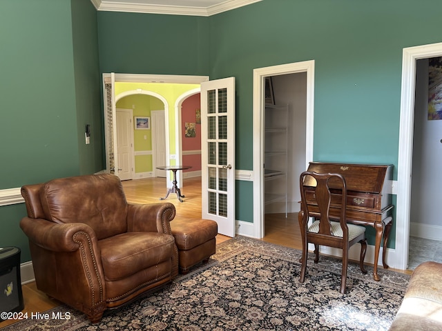 living area featuring crown molding and hardwood / wood-style flooring