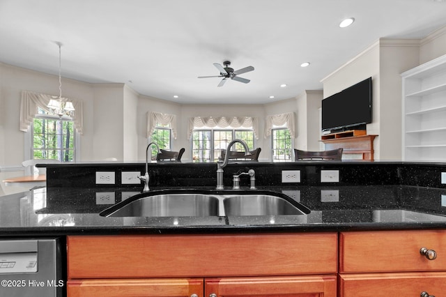 kitchen with dark stone counters, ceiling fan with notable chandelier, stainless steel dishwasher, and a sink