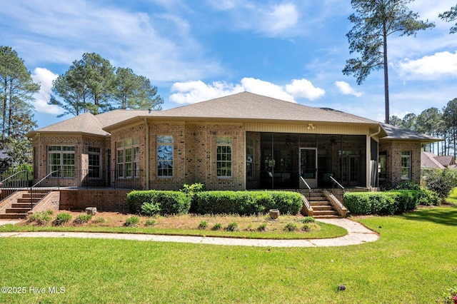 back of house featuring brick siding, a yard, a sunroom, stairs, and ceiling fan