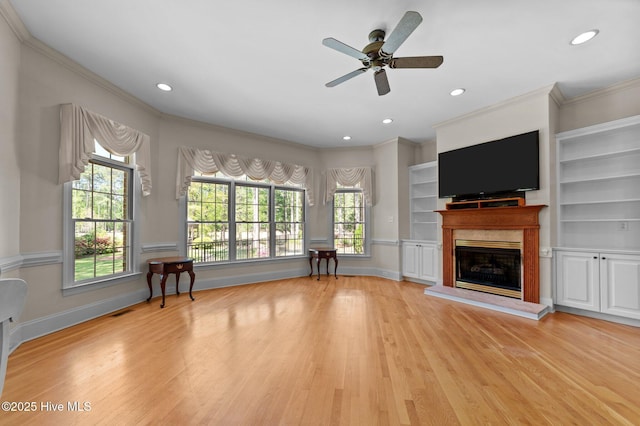living area featuring a high end fireplace, crown molding, and wood finished floors
