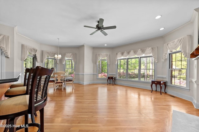interior space featuring recessed lighting, ornamental molding, baseboards, light wood-style flooring, and ceiling fan with notable chandelier