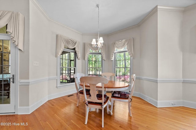dining space with visible vents, baseboards, wood finished floors, and a notable chandelier