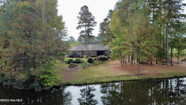 rear view of house featuring a gazebo and a water view