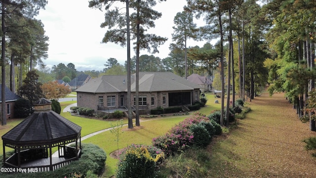 rear view of property with a gazebo and a yard