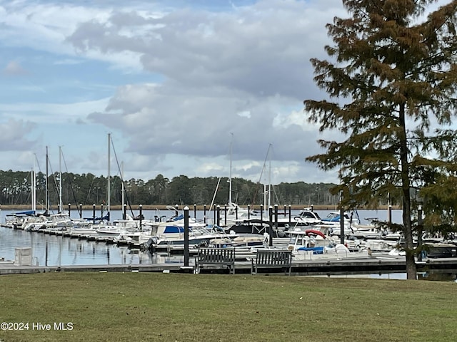 dock area with a lawn and a water view