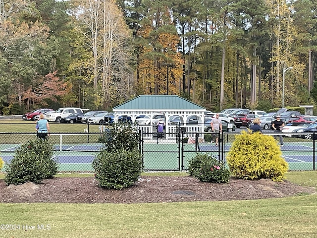 view of home's community with fence and uncovered parking