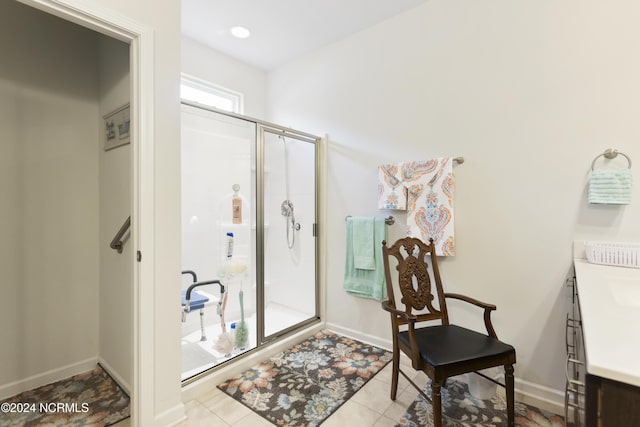 bathroom with tile patterned floors, baseboards, a stall shower, and vanity