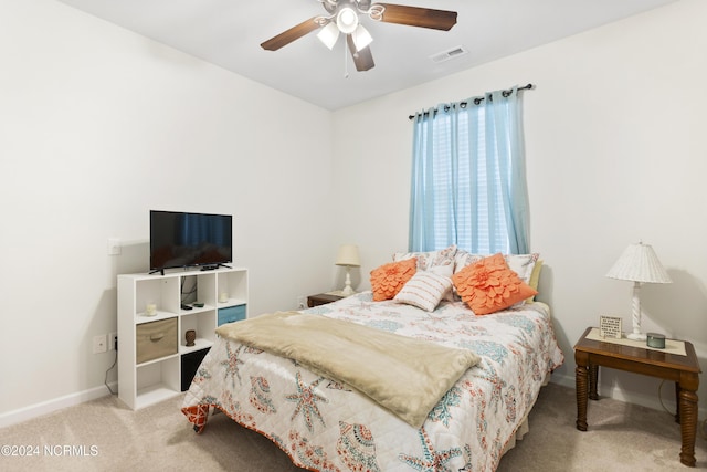 bedroom with a ceiling fan, baseboards, visible vents, and light carpet