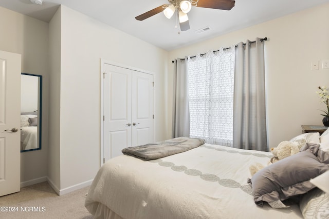 bedroom with a ceiling fan, visible vents, baseboards, a closet, and light colored carpet