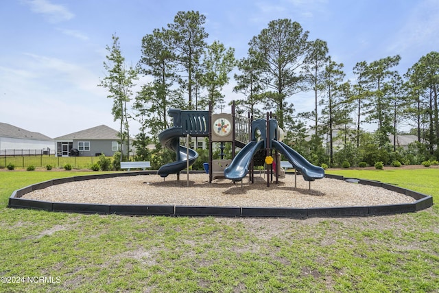 community play area featuring a lawn and fence