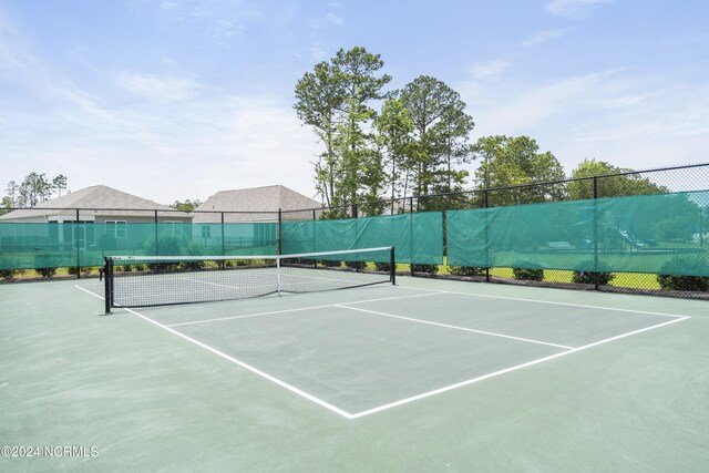 view of tennis court with community basketball court and fence