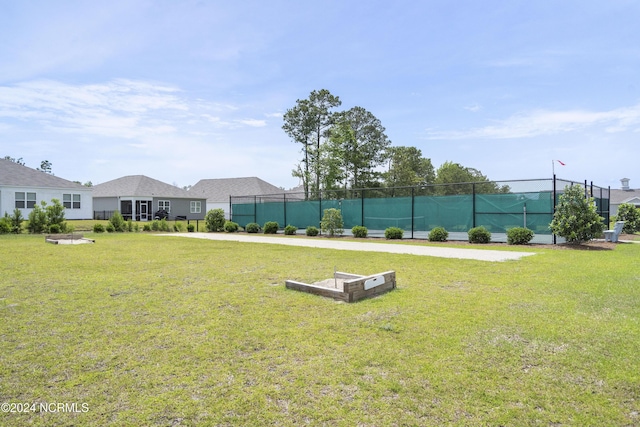 view of home's community with a lawn and fence