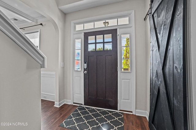 entrance foyer with a barn door and dark hardwood / wood-style floors