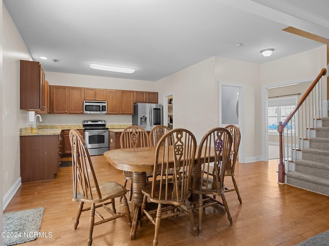 dining space featuring light hardwood / wood-style flooring and sink