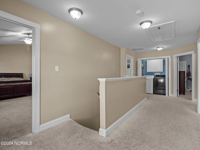 corridor with washing machine and dryer and light colored carpet