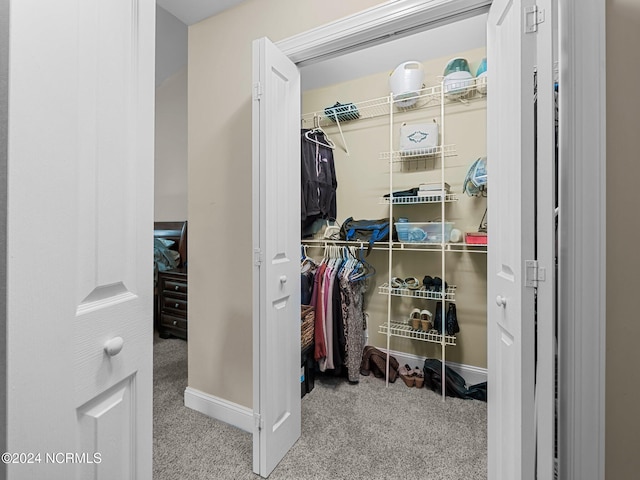 walk in closet featuring light carpet