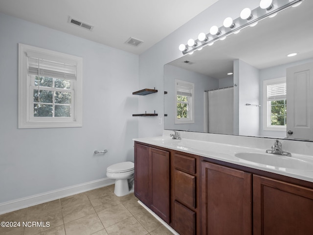 bathroom featuring a wealth of natural light, tile patterned flooring, vanity, and toilet