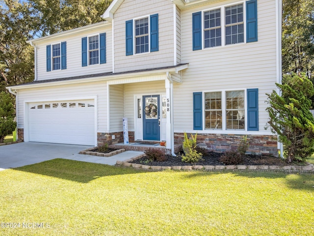 view of front of property with a front yard and a garage