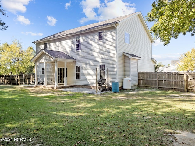 rear view of property with a patio area and a yard