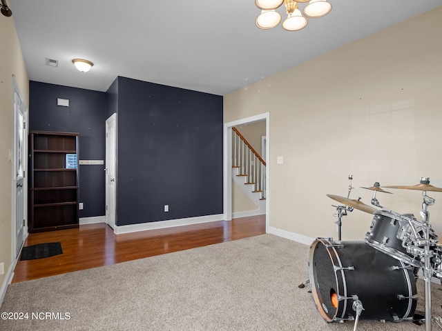 workout room with a notable chandelier and hardwood / wood-style flooring