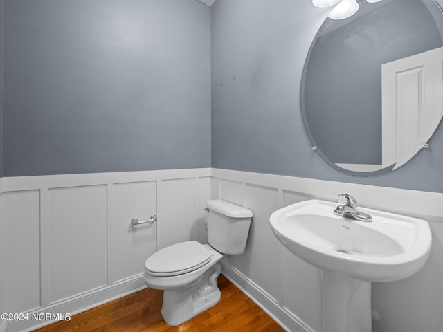 bathroom with toilet and hardwood / wood-style flooring