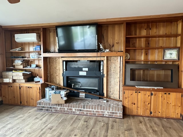 living room featuring a wall mounted air conditioner and light hardwood / wood-style flooring