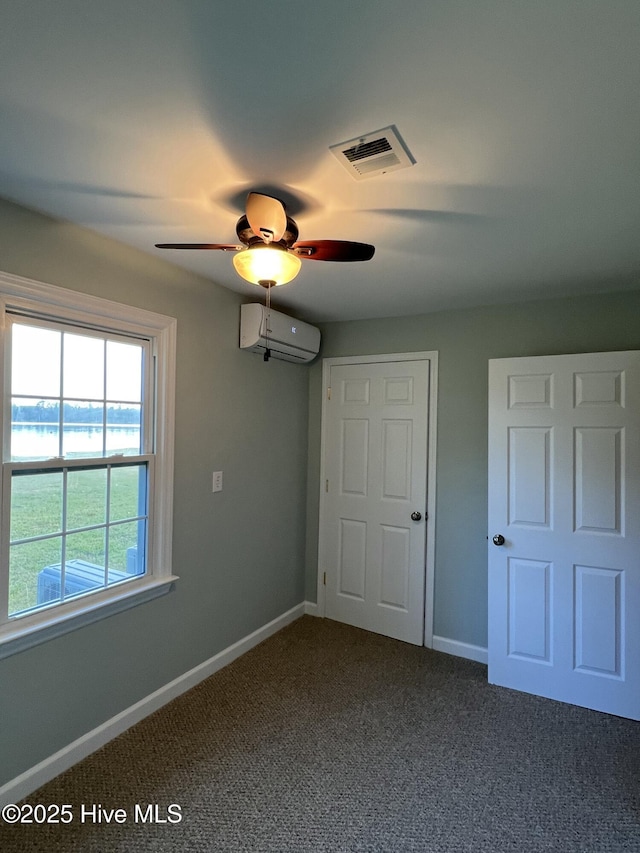 unfurnished bedroom featuring carpet floors, an AC wall unit, and ceiling fan