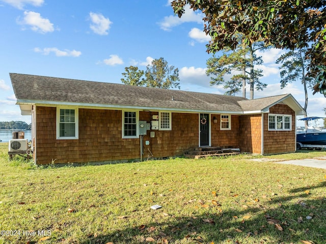 single story home featuring a water view, ac unit, and a front lawn