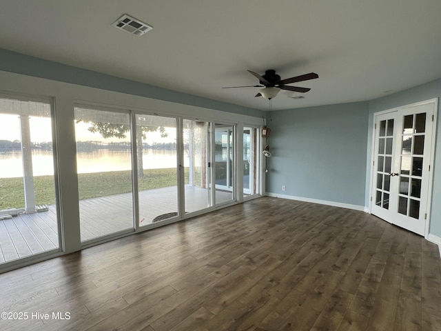 unfurnished sunroom featuring french doors, a water view, and ceiling fan