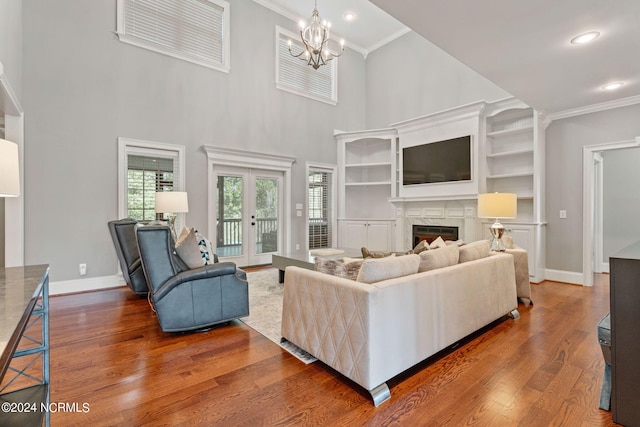 living room with crown molding, dark wood-type flooring, a high end fireplace, and a high ceiling