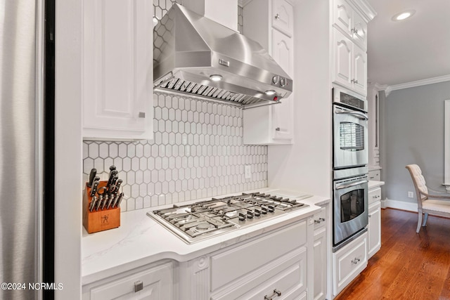 kitchen featuring decorative backsplash, light hardwood / wood-style flooring, ornamental molding, and white cabinets