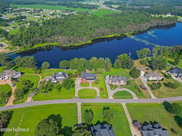 drone / aerial view with a residential view, a water view, and a view of trees