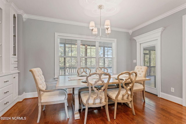 dining area with wood-type flooring, a healthy amount of sunlight, a notable chandelier, and crown molding