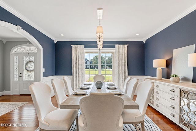 dining space featuring crown molding and dark wood-type flooring