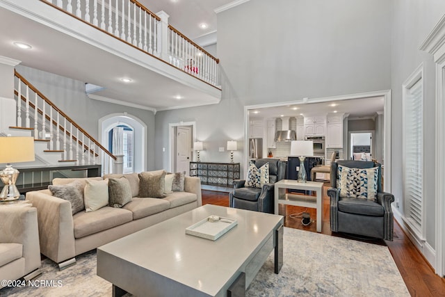 living room featuring ornamental molding, hardwood / wood-style floors, and a high ceiling