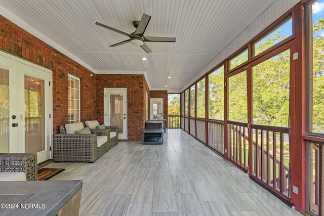 unfurnished sunroom with ceiling fan and french doors