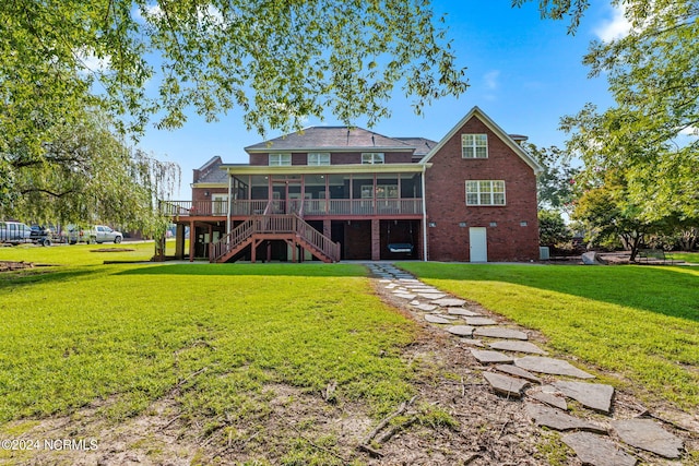 back of property featuring a wooden deck, a sunroom, and a yard