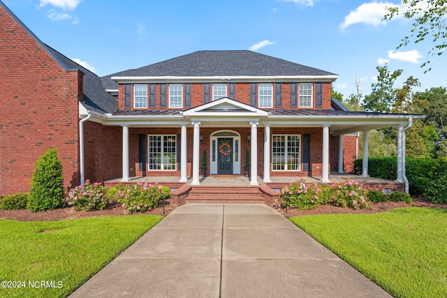 view of front of property with covered porch and a front lawn