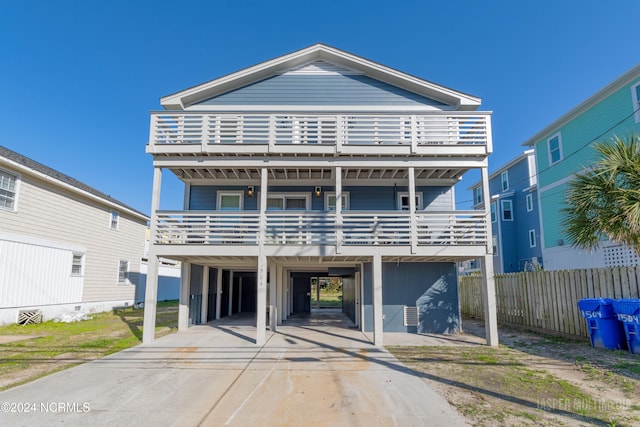 view of front facade with a carport and a balcony