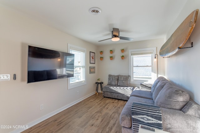 living room with light wood-type flooring and ceiling fan